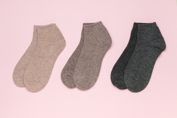 A set of three pairs of short socks on a pink background.