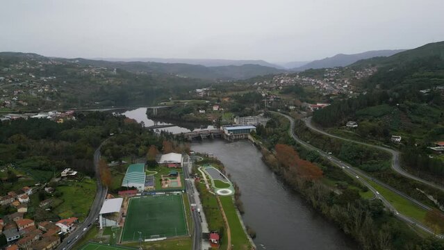 Aerial establishing view of Velle water dam and power plant in city of Ourense, Galicia, Spain on grey cloudy day