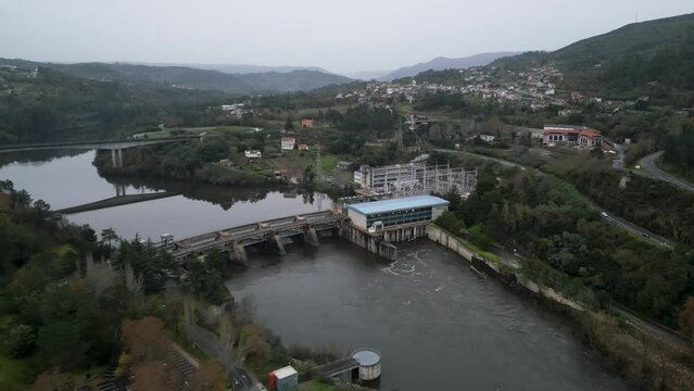 Angled push in drone to flowing water from Velle water dam and power plant in Ourense, Galicia, Spain