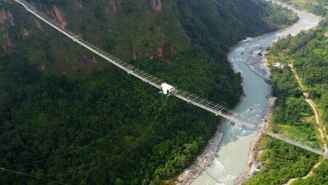 Kushma bungee jumping off suspension bridge high above ravine 