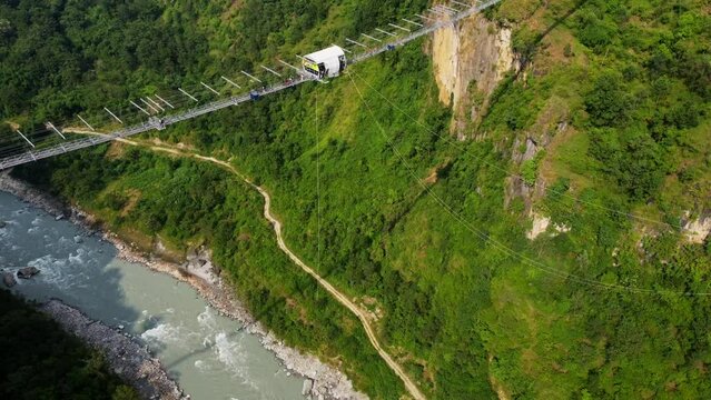 Person hanging from Kushma bungee jump off suspension bridge 