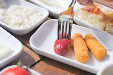 Close up of fork pick smoked salami sausage