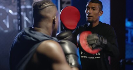 Man, fighter and boxing with personal trainer in ring for practice, coaching or sports training at night gym. Person or coach with professional boxer in evening arena for self defense, MMA or combat - Powered by Adobe