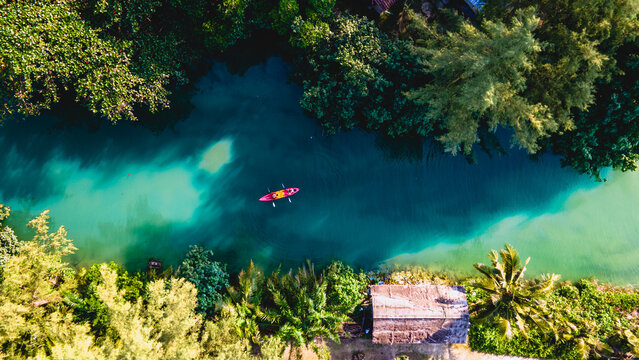 Couple men and women peddling in a kayak during the afternoon at sunset, People in a Kayak at a river klong of a tropical Island Koh Chang Thailand during sunset