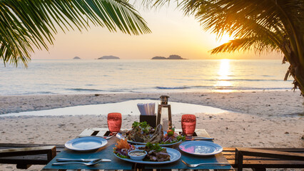dinner table on the beach at sunset on the Island of Koh Chang Thailand. dinner table with seafood