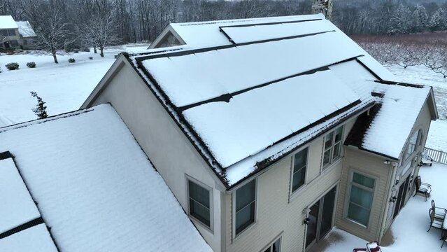 Solar panels covered in snow in New England, USA. Aerial view of inefficient power source during weather.