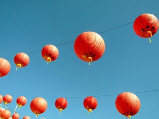 Red Chinese paper lanterns against blue sky