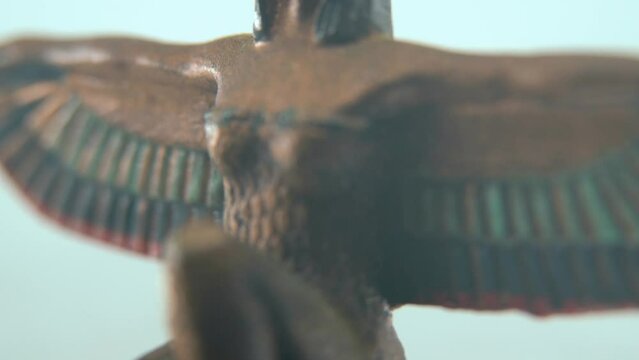Dreamy macro shot of a Cleopatra statue with wide open wings, hazy depth of field, ancient Egypt Queen of Kings, Egyptian historical ruler, antique artwork of a goddess, 4K video tilt up