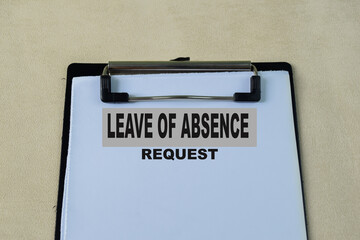 Concept of Leave of Absence request write on paperwork isolated on wooden background.