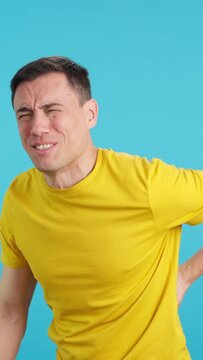 Man gesticulates that he is in back pain