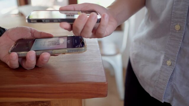 Friends using smartphone for payment at cafe restaurant for split payment
