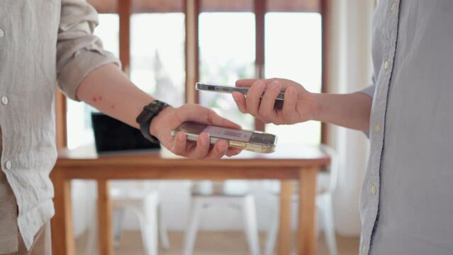 Friends using smartphone for payment at cafe restaurant for split payment