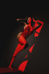 Beautiful asian girl in lingerie posing in the red lights. Beauty and fashion concept.