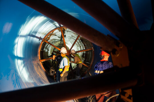 Engineers wear helmet, vests safety .Technician control underground tunnel construction at working shaft to maintenance of Water supply pipe by Tunnel Boring Machine(TBM) method for train.
