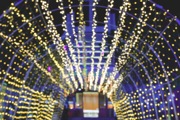 Blurred image bokeh background of Christmas decorative tunnel lights in front of entrance door of...