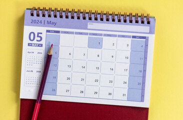 Desk calendar for May 2024 on a yellow background.
