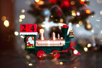 Christmas toy locomotive near the Christmas tree. December 24. Christmas. Christmas card