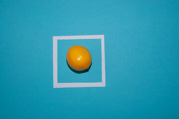 Tangerines and paper frame shape of cube on a blue background. Flat lay. Fruit minimal concept. 