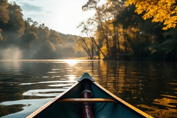 Fototapeta premium Tranquil canoe trip on a calm river with golden sunlight filtering through autumn trees.