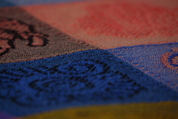 Macro of colourful cloth, square design with different colours and symbols, texture