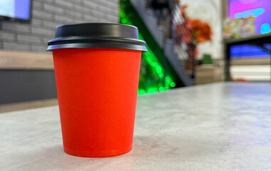 Red paper cup for coffee on the table