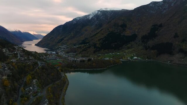aerial view of city of odda during morning during morning in norway with lakes and mountains on background