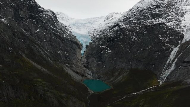aerial view of briksdalsbreen glacier and blue glacial lake from high altitude in norway