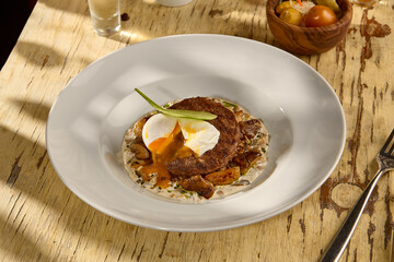 Beefsteak with an egg and white mushrooms, a rich and savory dish