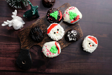 Homemade Glazed Christmas Donuts. Assorted Christmas design donuts include reindeer, Santa Claus, Xmas tree, and chocolate. festival background. copy space. festive or holiday concept.