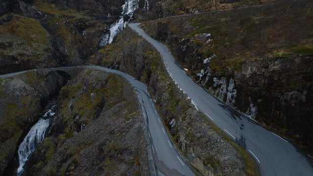 aerial view of winding road of trollstigen the trolls ladder with stigfossen waterfall on background