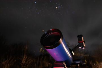 A large amateur astronomical telescope is aimed at the night starry sky and is ready for...