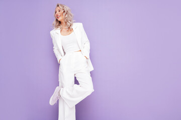 Portrait of young beautiful blond woman wearing nice trendy white suit. Fashion model posing in...