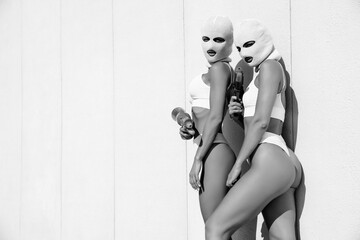 Two beautiful sexy women in underwear. Models wearing bandit balaclava mask. Hot seductive female...