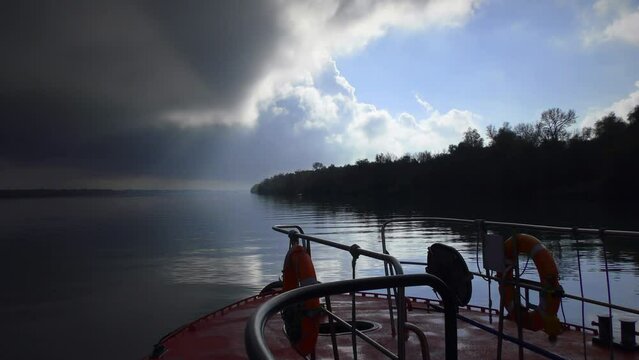 The ship is moving along the Danube under the border of the interdisciplinary sky and a huge thundercloud.
