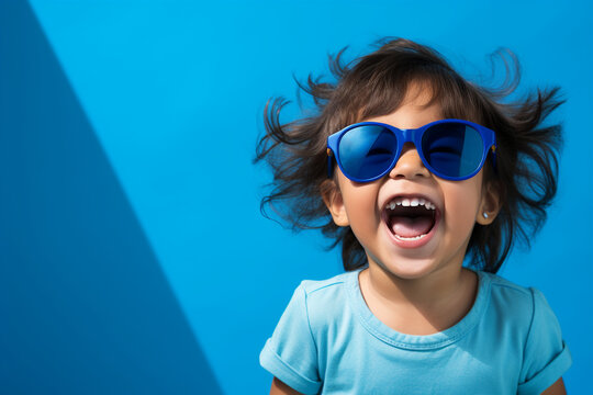 A jubilant South Korean child, dressed in soothing shades of blue, radiates joy against a peaceful blue backdrop, highlighting the joy of cultural diversity.