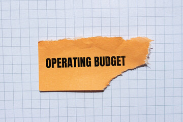 Operating budget lettering on ripped paper. Business concept photo.