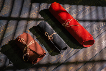 Leather rolls on the old wooden workbench background top view. Leather craft concept background.