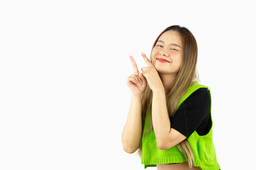 Fototapeta premium Young asian woman long hair style in green shirt posing smiling face and fingers pointing for advertising text copy space isolated on white background