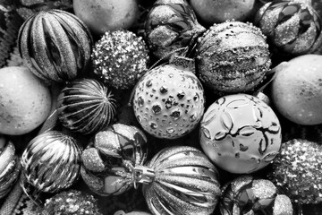 New Year's Christmas balls and decorations close up surface. Monochrome black white silver. Striped...