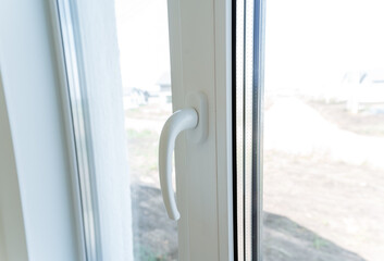 Plastic window, white handle on the double-glazed window, house decoration elements, double glazing. - obrazy, fototapety, plakaty