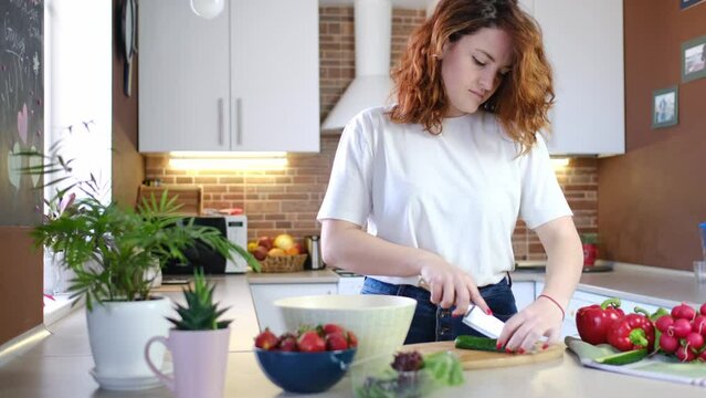 young caucasian woman make healthy food salads in home kitchen with vegetables and organic ingredients close-up background. Healthy breakfast. Vegan lifestyle