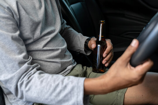 A man is drinking beer while driving
