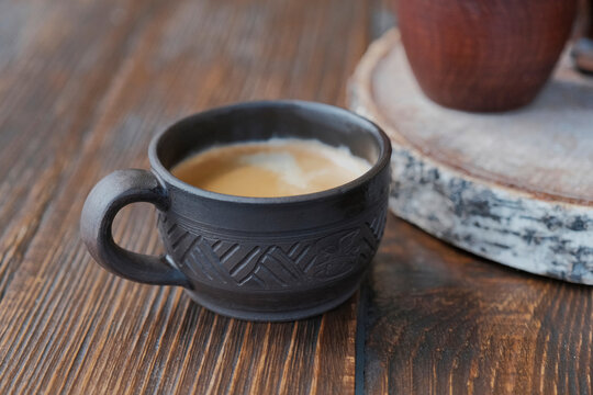 Clay cup with black coffee.