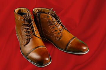 A pair of premium calfskin boots on a red background. Horizontal shot.