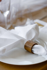 Banquet table setting in blue and white colors, top view. In the center of the table is a bouquet of bright exotic flowers on a drapery. Candles in gold candlesticks, plates with napkins, glasses.