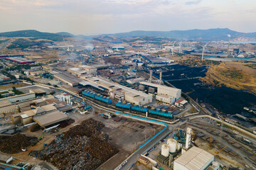 Power Plant in heavy industrial estate with coal heaps open coal bulk storage terminal. Aerial