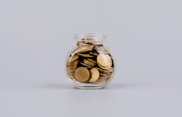 Saving money coins in a glass bottle Concepts of saving money, cash flow, assets and real estate....