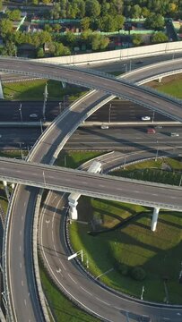 Multi-level road junction and cars traffic. Drone is flying to the right. Aerial vertical shot. Vertical Video