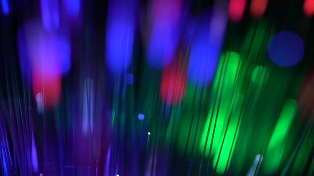 Beautiful thin glowing sticks of blue, green, red color move on a black background