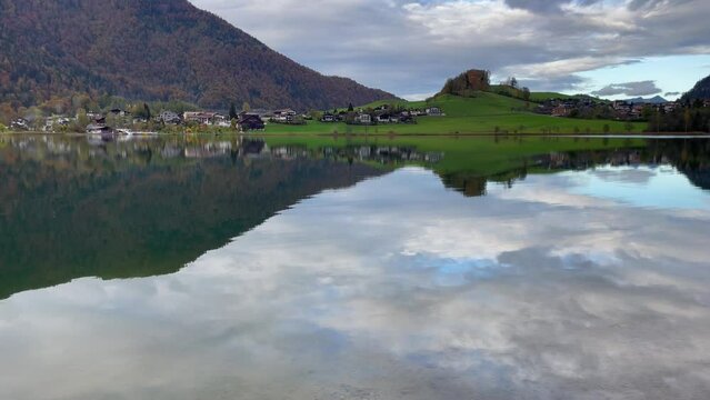 Thiersee lake and reflection of mountains on water on cloudy day in Austria. Peaceful natural landscape in European countryside